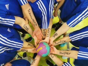 Mehrere Personen legen ihre Hände in einem Kreis zusammen – Symbol für Gemeinschaft, Teamgeist und Zusammenhalt.