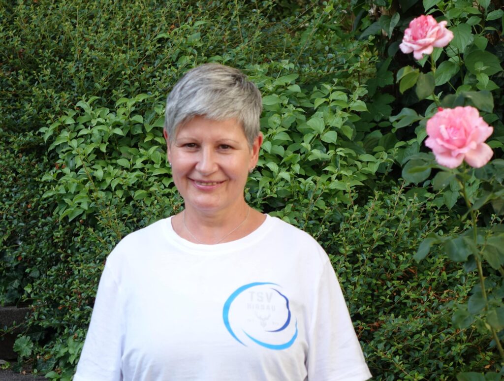 Kerstin Heike vom TSV Hirsau steht vor einer blühenden Hecke und lächelt freundlich in die Kamera.