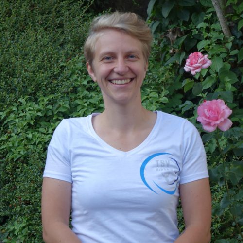 Laura Schröder – 3. Vorsitzende TSV Hirsau Laura Schröder, 3. Vorsitzende des TSV Hirsau, lächelt vor einer blühenden Hecke in die Kamera