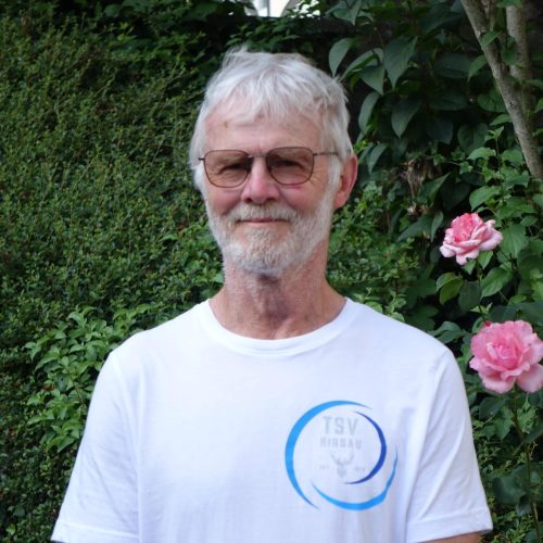 Klaus Morgeneier-Hammes – 2. Vorstand TSV Hirsau Klaus Morgeneier-Hammes, 2. Vorstand des TSV Hirsau, vor einer blühenden Gartenkulisse.