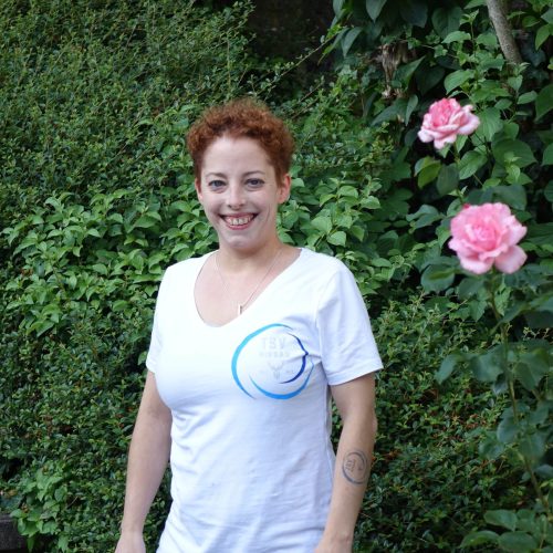 Cathrin Börner-Mast – Schriftführerin TSV Hirsau Cathrin Börner-Mast, Schriftführerin des TSV Hirsau, steht vor einer blühenden Hecke und lächelt freundlich